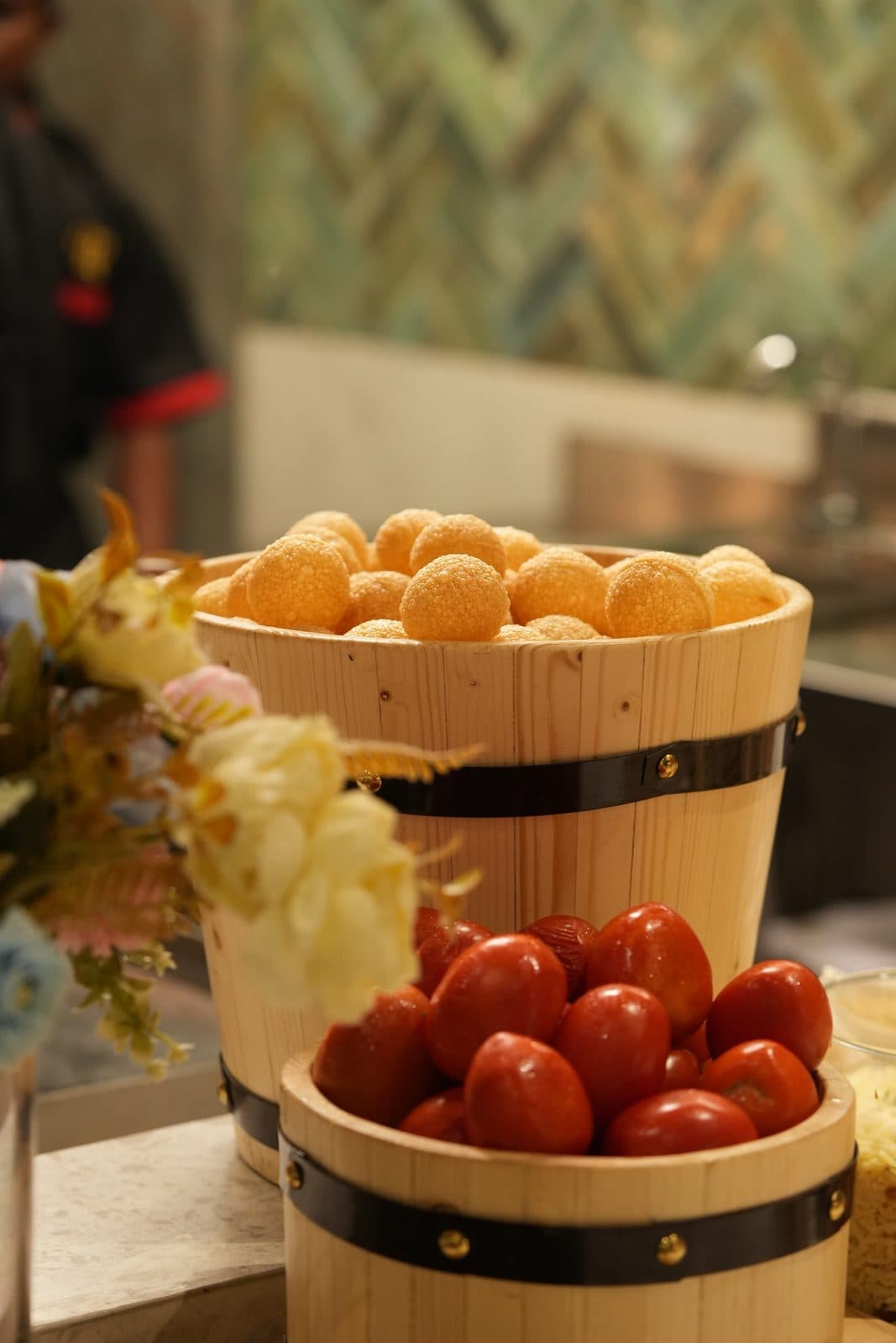 Baskets of pani puri shells and tomatoes at the chaat station