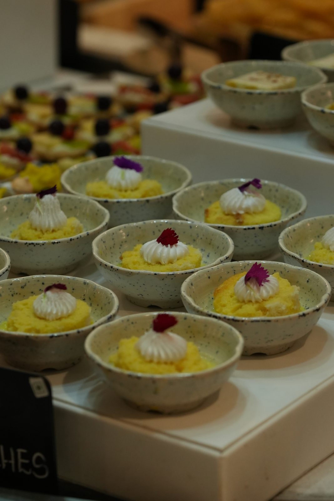 Bowls of dessert topped with cream and edible flowers