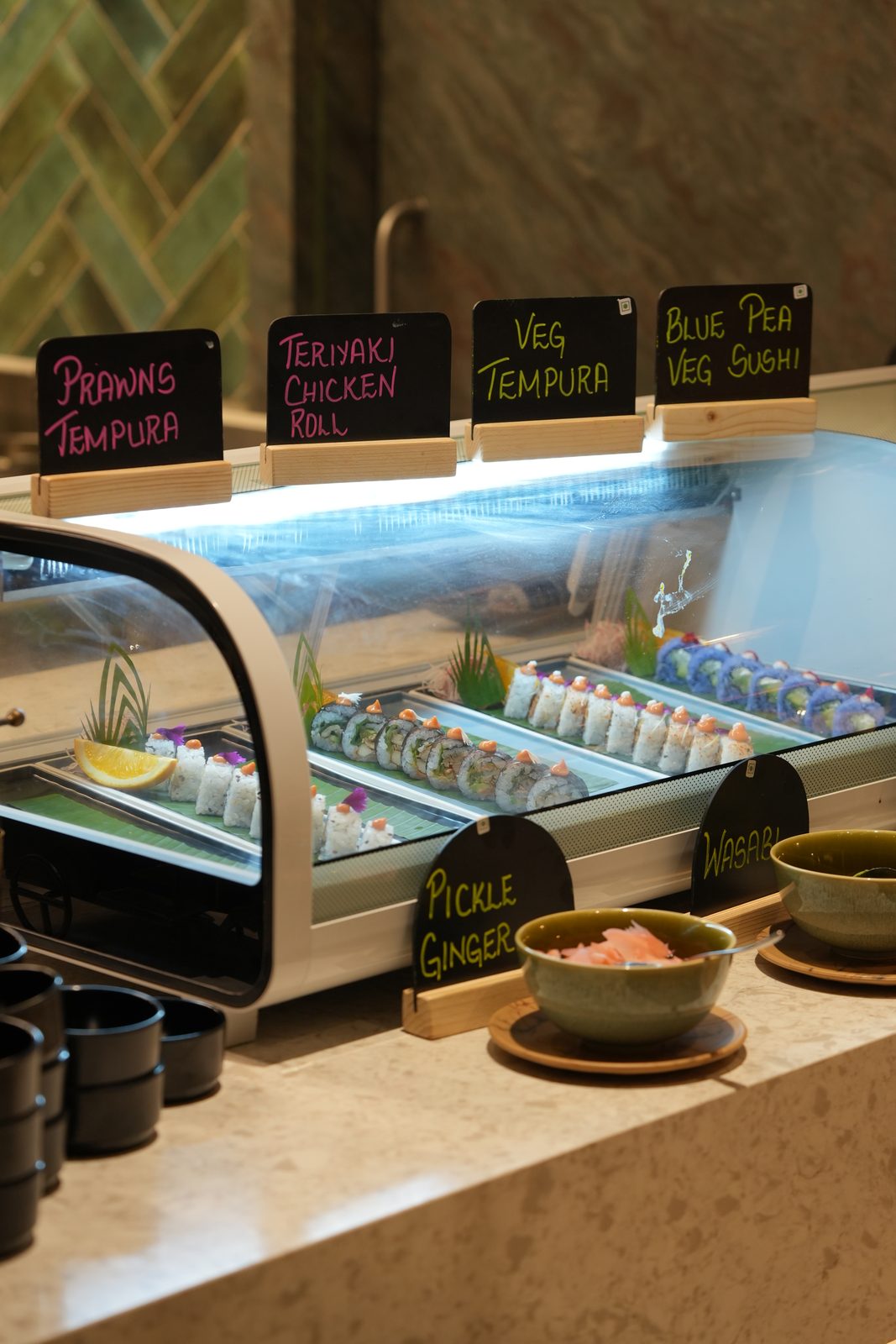 The sushi display case with tempura and teriyaki rolls